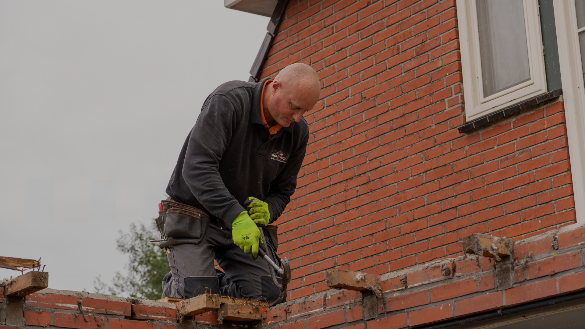 Bouwvakker werkt aan een bakstenen muur - Mulder Bouwbedrijf (over) ( Nieuwbouw)